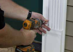 Screwing a Spectis pilaster to the installation strip beside the door